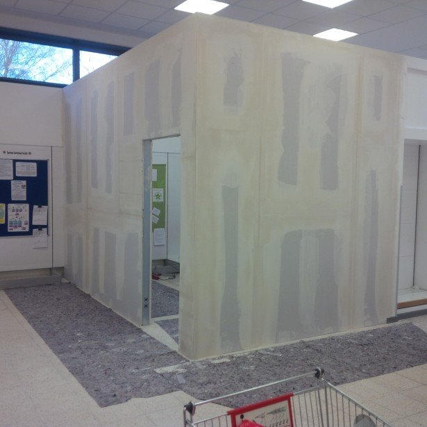 Drywall partitions under construction inside a commercial interior