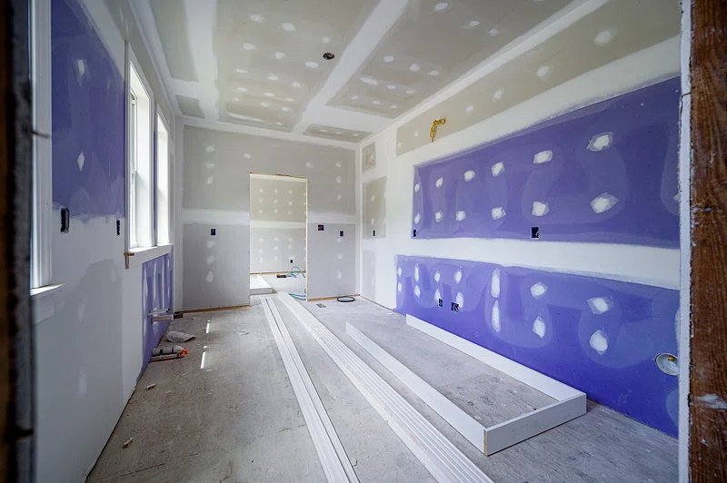 New drywall sheets and taped joints inside a residential renovation